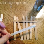 Lay out your craft sticks vertically to create your fence. Use two craft sticks and glue them horizontally to hold the vertical sticks in place. Let dry.